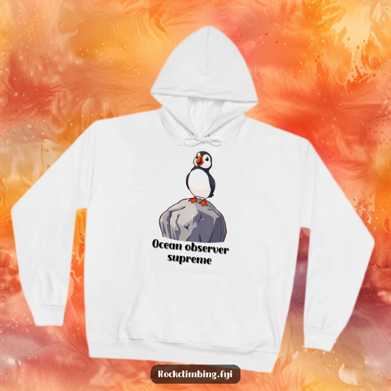 Funny hoodie featuring a delighted puffin perched on a high rock, enjoying a serene view of the sea, offering cozy coastal humor.