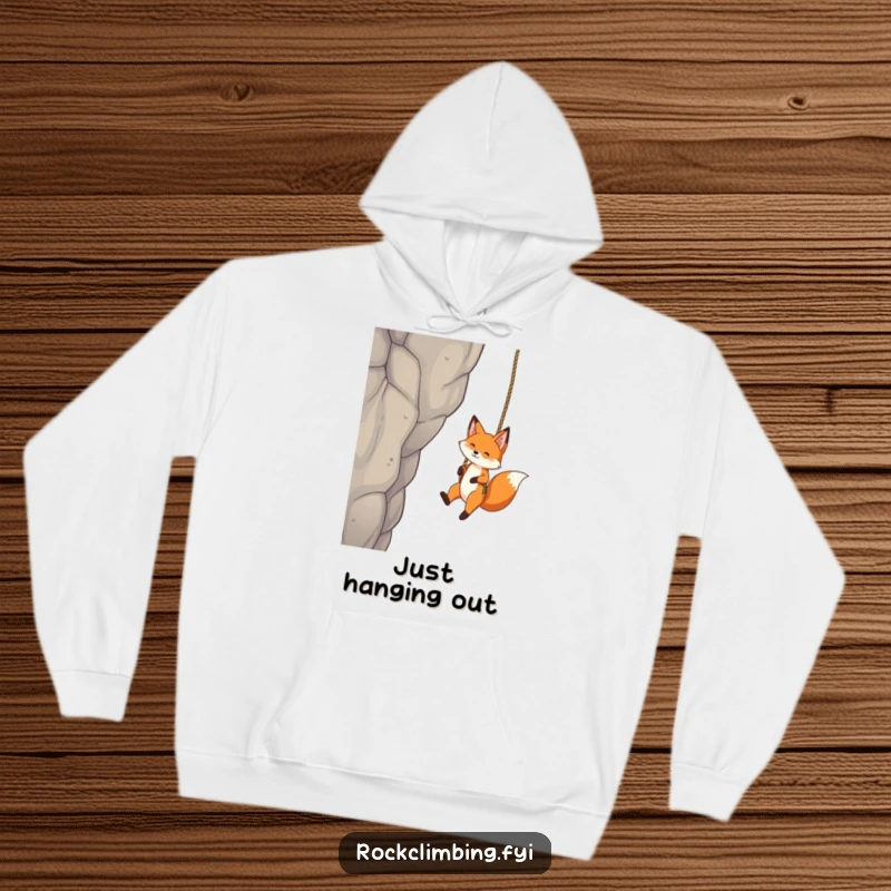 Funny Fox Hoodie: A playful fox hangs suspended from a rope swing against a tall crag, showcasing thrilling fun.